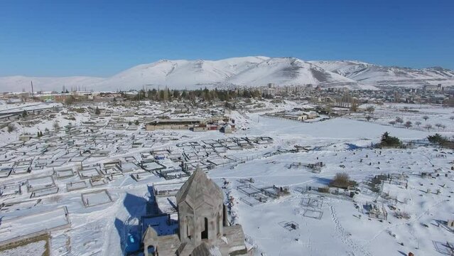 Unfinished church near cemetery and townscape near mountains