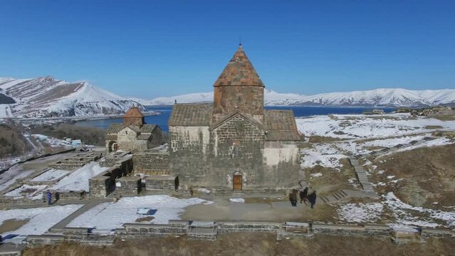 People walk near Sevanavank monastic complex on hill 
