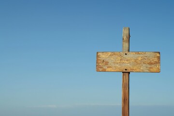 Guiding us towards the endless possibilities of the great outdoors, a simple wooden sign post stands tall against the serene blue sky, a symbol of adventure and discovery waiting at the beach