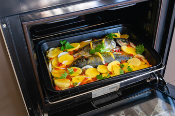 Delicious raw mackerel with potatoes and tomato, onion, lemon and spices in a dish prepared to put...