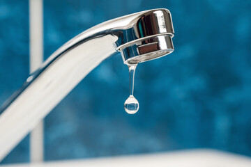 A drop of water drips from a leaky faucet