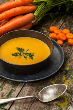 Homemade carrot soup in rustic kitchen setting