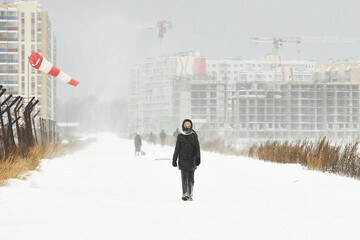 Person Walking Down a Snow Covered Road in a Winter Snowstorm
