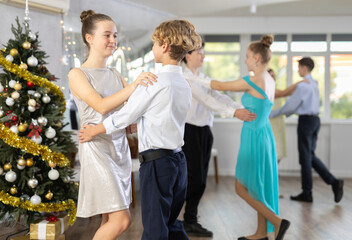 Couple dancing of beautifully dressed teenagers during the Christmas celebration