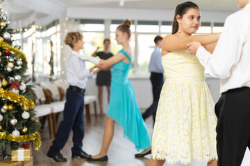 Couple dancing of beautifully dressed teenagers during the Christmas celebration