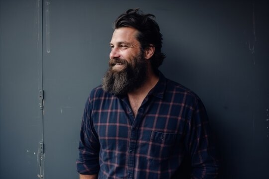 Portrait of a handsome man with long beard and mustache wearing a checkered shirt