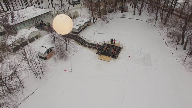 Balloon flies above outdoor pool with people do baptistery submersion