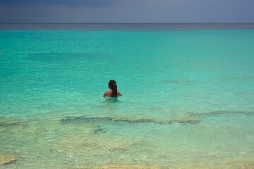 Fototapeta na wymiar A photo of a young African Caribbean man with dreadlocks refreshing in the azure blue sea. 