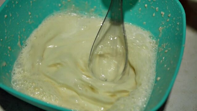Cooking delicious homemade pancakes from organic products.  The process of mixing milk, eggs and flour in a bowl using an electric mixer with a dasher.  Pancakes are a good snack for breakfast. 