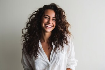 Portrait of a beautiful young woman with long curly hair smiling at the camera