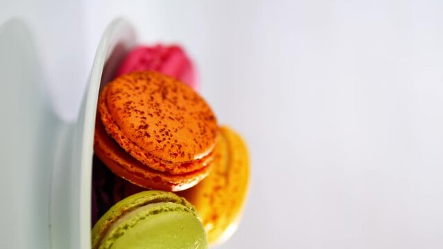 Close-up of colorful macarons cakes on white plate. macaroon desserts and sweets. sugar consumption