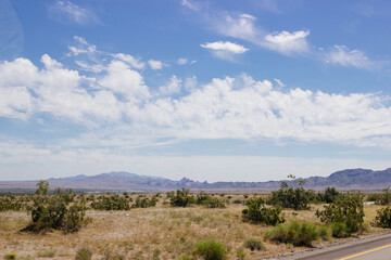 Beautiful blue sky with fluffy clouds over a desert with mountains in Arizona, USA. Panorama with high hills. Landscape on a sunny day