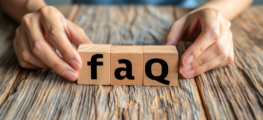 man puts wooden blocks with the word FAQ - frequently asked questions. 