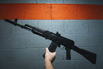 Russian assault rifle AK 74m with a collimator sight in a man's hand.