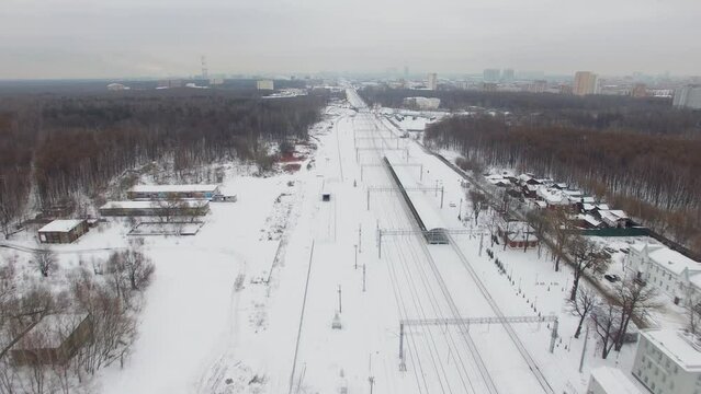 Snowbound Moscow ring railway and townscape at winter cloudy day. Aerial view