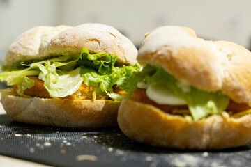 Fish sandwich with lettuce and egg on bun bread. selective focus, close-up.