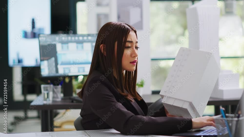 Poster developer analyzing 3d building model at realty office, examining measurements for the actual constr