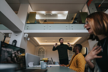 Casual business team in a creative office setting, interacting with enthusiasm and a dynamic vibe.