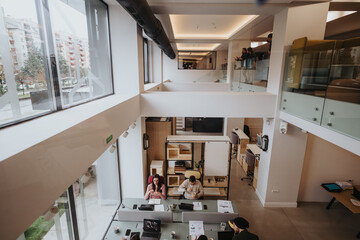Modern open-plan office space with busy creative professionals at work.