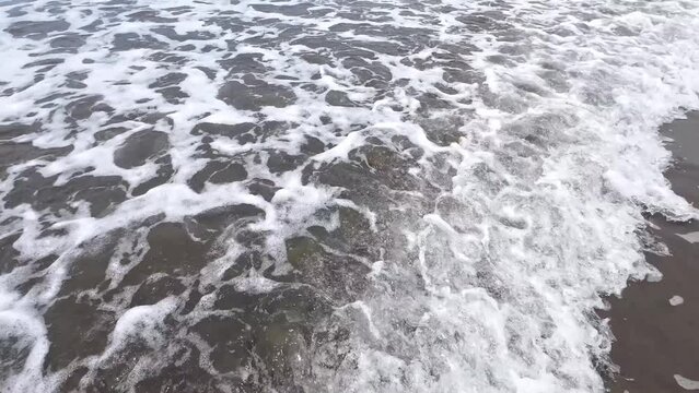 Dreamy scene on the beach - Gentle waves break on the shore, foaming up picturesquely. The sound of the sea creates a calming backdrop. A perfect moment of natural splendor. copy space