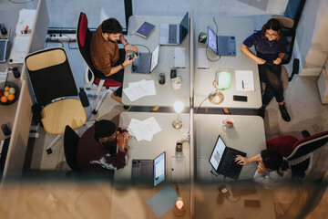 Top view of a diverse group of multigenerational business colleagues working together in a collaborative office environment during an engaging meeting.