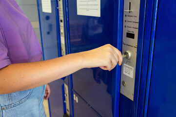 Close up of traveler hand use the coin locker (luggage office) for storing luggage while traveling around the city