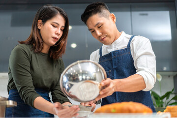 Young asian family couple having fun cooking together with dough for homemade bake cookie and cake...
