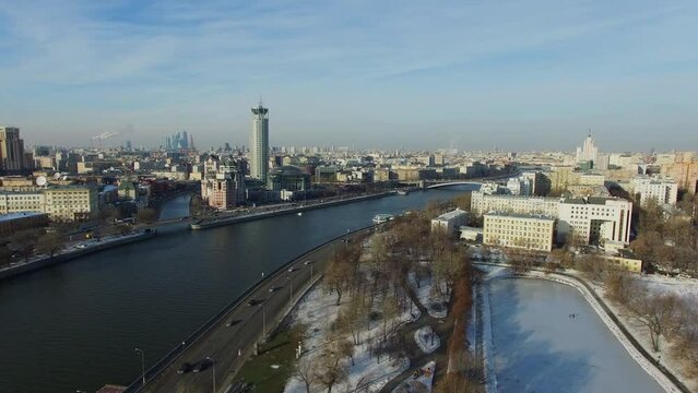 Cityscape with traffic on river embankment at sunny day. Aerial view