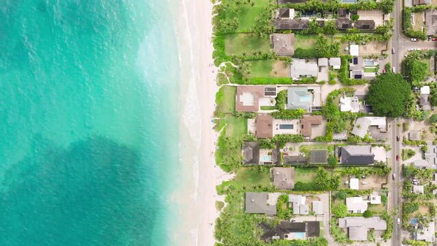 Top down shot over ocean front properties on scenic Hawaii Island. Real estate business for sale offer copy background. Expensive beach villas and cottage in Kailua town. Luxury lifestyle Oahu USA 4K