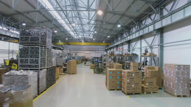 Stacks with goods and production line hardware in workshop 