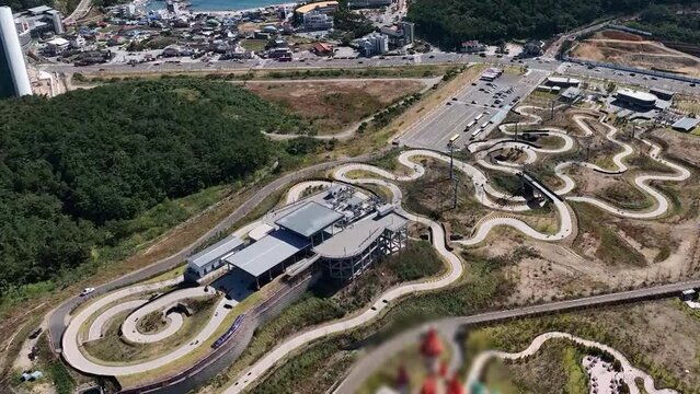 부산 기장의 핫플레이스 루지 항공 영상과 루지를 타고 내려오는 관광객
