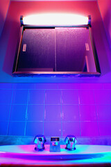 grunge neon retro tile bathroom sink faucet and dirty mirror with purple pink and blue light