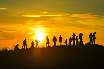 Group of People Standing Atop a Hill, Enjoying the View