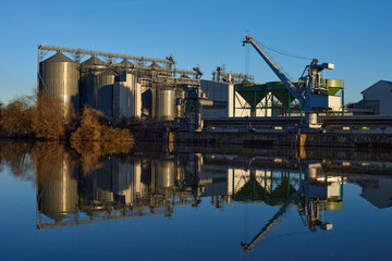 Fototapeta premium Riverside Manufacturing at Dusk. Environmental Technology and Production. Riverside Manufacturing Hub. Eco-Friendly Technology and Production. industry and the environment, showcasing the integration