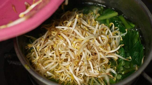 the process of boiling raw vegetables consisting of mustard greens, long beans and sprouts which will be boiled and used as ingredients for making pecel dishes