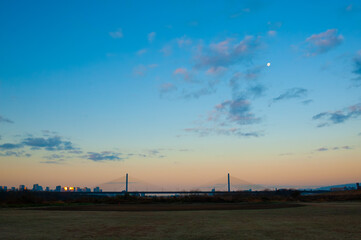 夕暮れ時の都市スカイラインと橋の風景