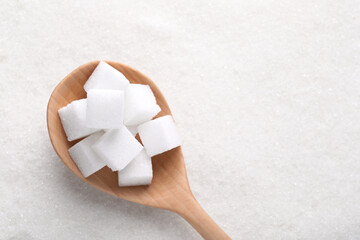 Different types of white sugar and spoon as background, top view. Space for text