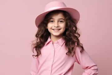 Portrait of a smiling little girl in pink hat over pink background