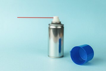 An aerosol can with lubricant on a blue background.