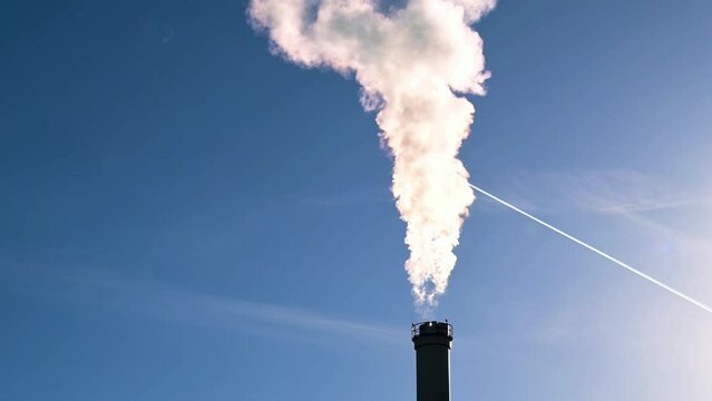 Ein Schornstein eines Heizkraftwerkes vor blauem Himmel