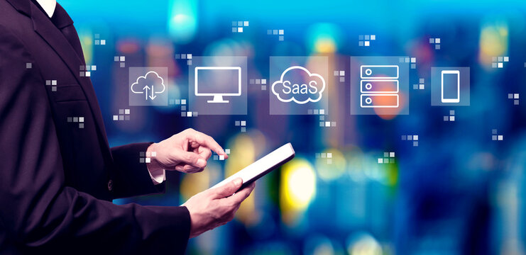 SaaS - software as a service concept with businessman using a tablet computer at night