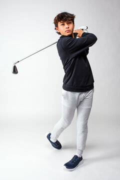 Teenage golfer watching his ball after teeing off with a driver club