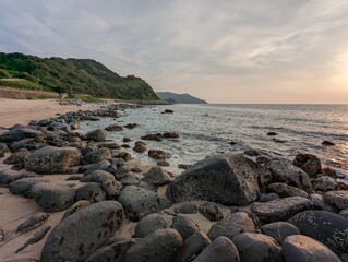 A serene and picturesque scene of a rocky beach at sunset.