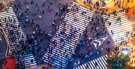 TOKYO - OCT 3rd, 2022: Traffic and people cross the Shibuya scramble intersection in Tokyo, Japan at night