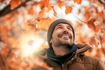 Homem agasalhado com blusa sorrindo ao ar livre no outono - obrazy, fototapety, plakaty