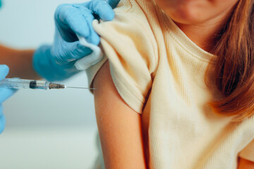 Nurse Vaccinating a Little Child for Future Disease Immunization. Kid getting an injection at the...