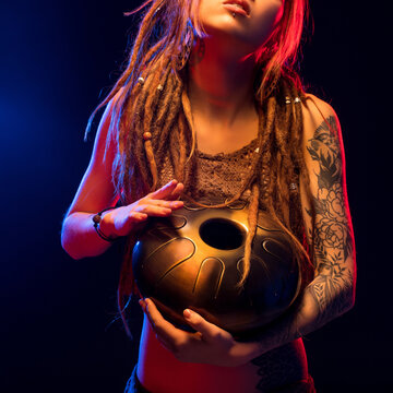 Girl with henna bodyart holding a hapi drum view