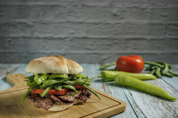 Chacarero with chili, green beans, meat, and tomato on a cutting board on a wooden table and copy space. Typical food and drink of Chile