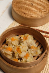 Delicious dim sum on bamboo steams. dim sum or dumpling is a snack from China and Hong Kong. Dim sum is made from chicken, pork, shrimp, squid, tapioca flour, and seasonings. Dimsum dumpling. 