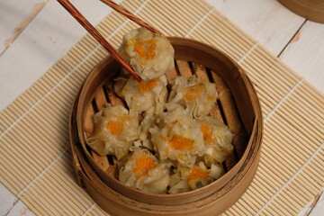 Delicious dimsum or siomay on bamboo steams. dimsum or dumpling is a snack from China and Hong Kong. Dimsum is made from chicken, pork, shrimp, squid, tapioca flour, and seasonings. Wonton dumpling. 
